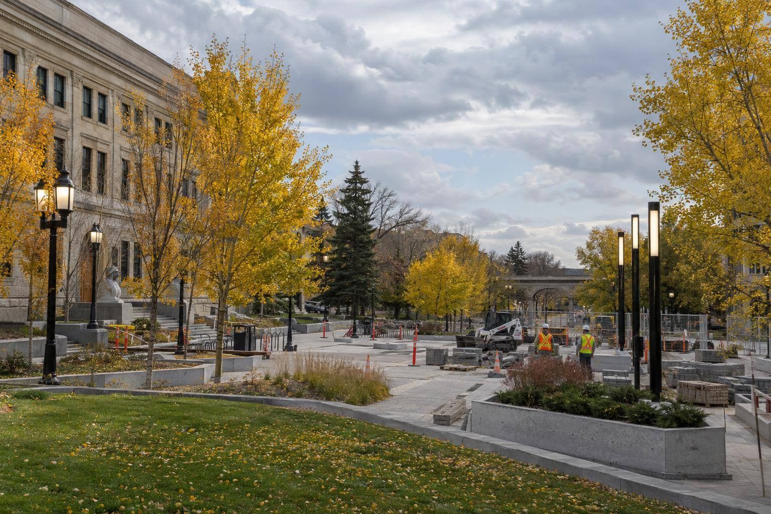 A downtown Calgary public space with upgraded lighting and visible safety infrastructure being installed or used around pedestrian areas, with no text or signage in the frame.